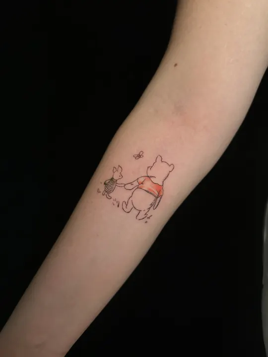 Ön kolda ince çizgi Winnie dövmesi, küçük renk detayıyla